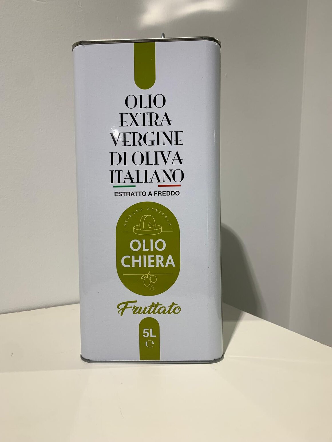 Olio extravergine fruttato accanto a pane e pomodori